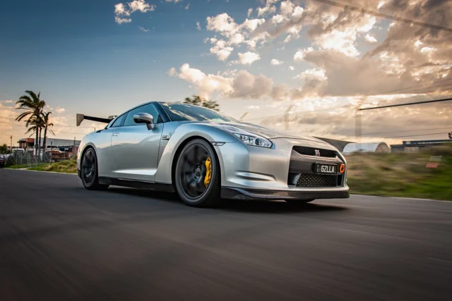 Silver sports car photographed at sunset